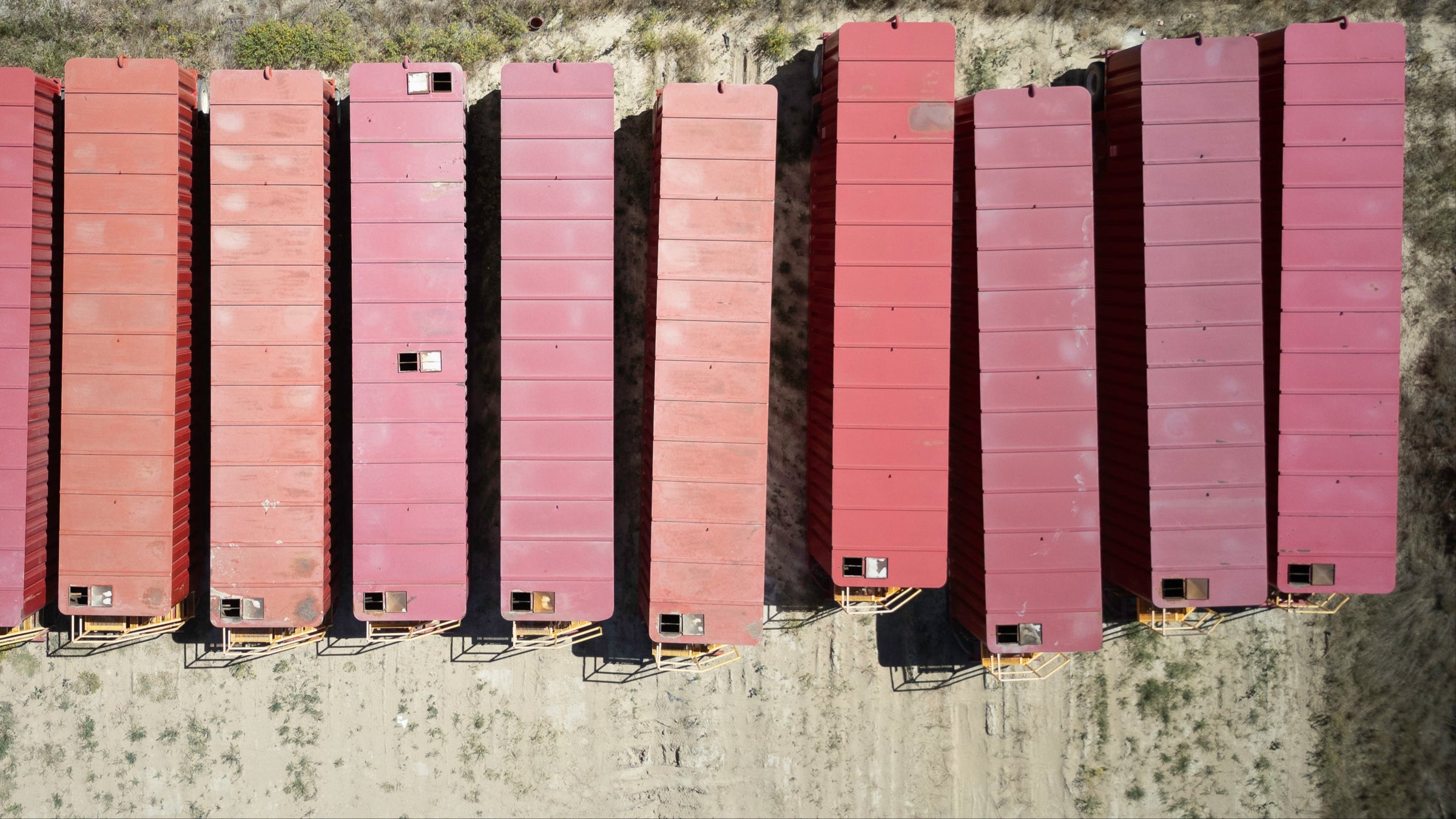 Aerial image birds eye view of a row of red used Dragon frac tanks