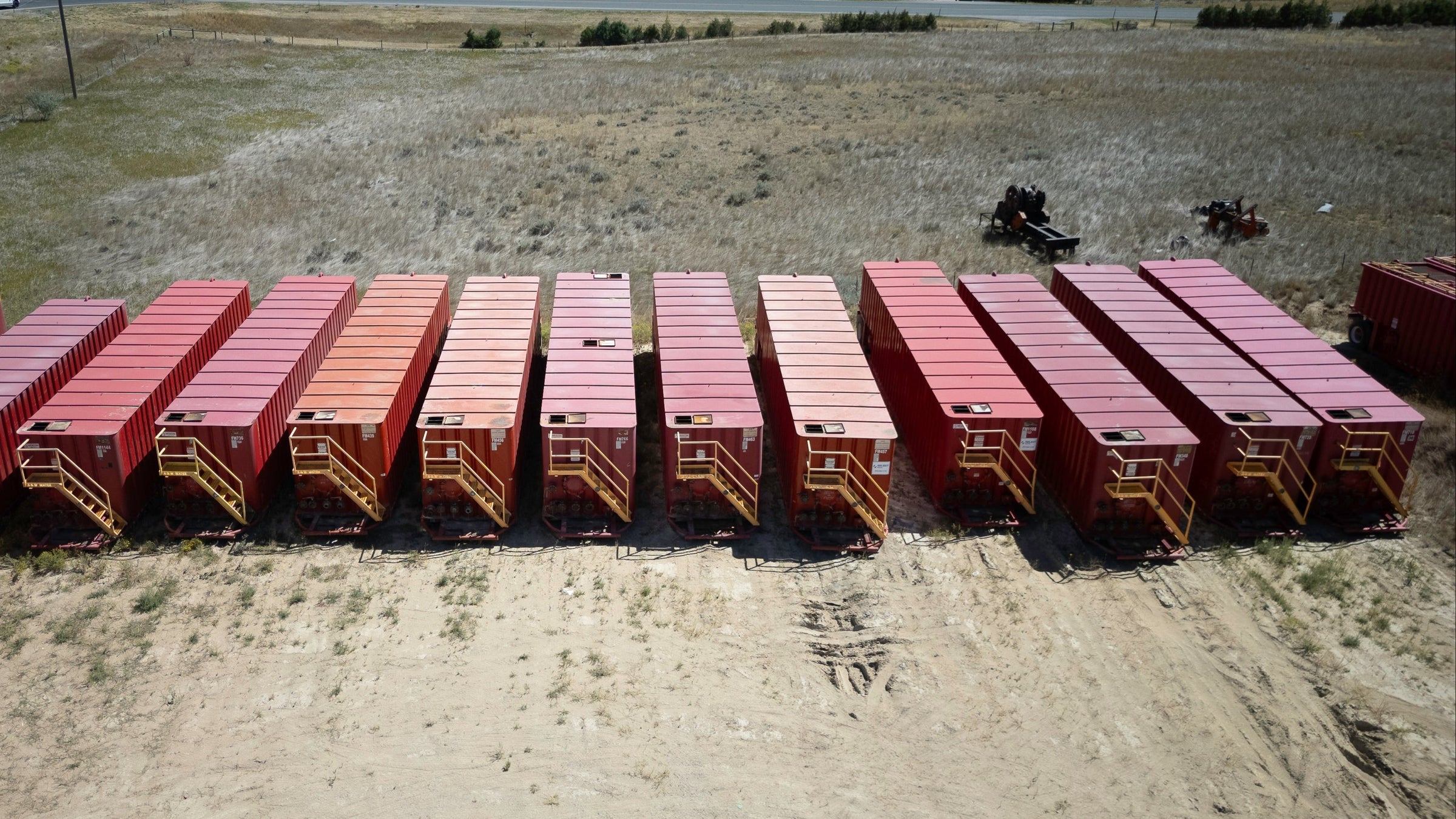 Red 21,000 gallon flat top frac tanks lined up 