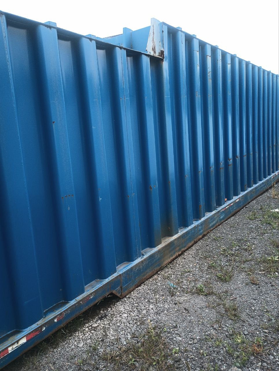 Close up side view of a blue used frac tank